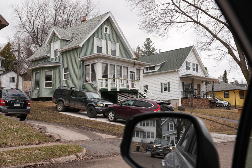 Cars slowly pass the home in the 700 block of East 12th Street where five people were found dead inside Wednesday after police received a report of a male experiencing a mental health crisis according authorities, Thursday, April 21, 2022, in Duluth, Minn. (Anthony Souffle/Star Tribune via AP)