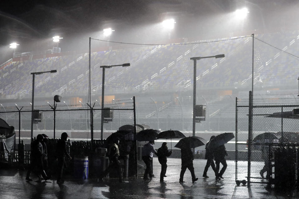 People leave the infield at Darlington Raceway after the NASCAR Xfinity series auto race was postponed because of rain Tuesday, May 19, 2020, in Darlington, S.C. (AP Photo/Brynn Anderson)
