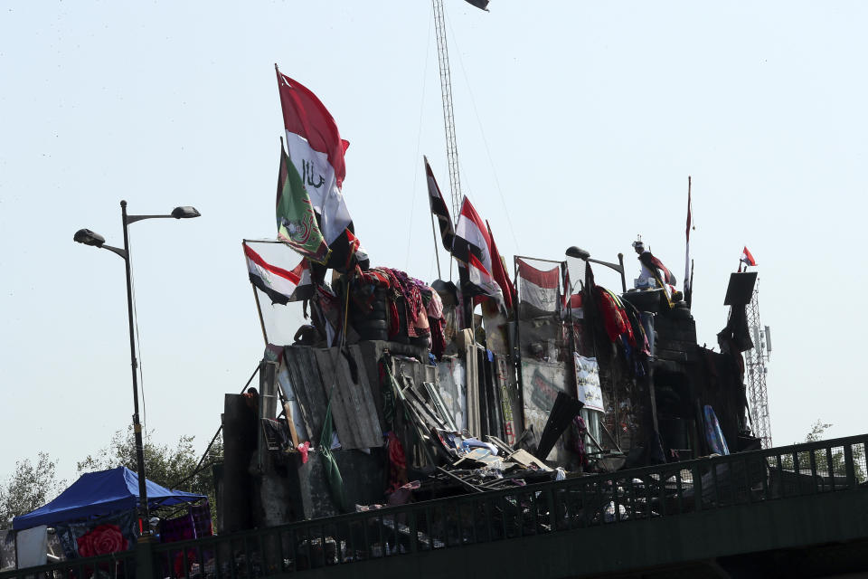 Anti-government protesters stand on barriers set by Iraqi security forces to close the Joumhouriya bridge leading to the Green Zone government areas during ongoing protests in Baghdad, Iraq, Monday, Nov. 4, 2019. (AP Photo/Hadi Mizban)