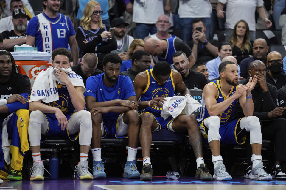 Golden State Warriors guards Klay Thompson, second from left, and Stephen Curry, second from right, sit on the bench during the second half of the team's NBA basketball play-in tournament game against the Sacramento Kings, Tuesday, April 16, 2024, in Sacramento, Calif. (AP Photo/Godofredo A. Vásquez)