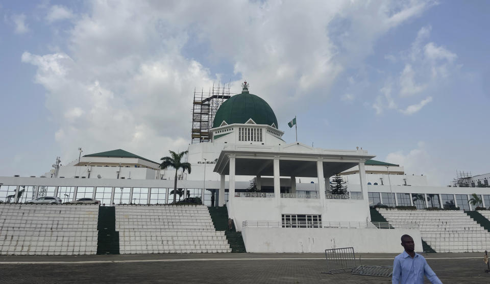 A man walks past the National Assembly building in Abuja, Nigeria, Thursday, Nov. 2, 2023. Nigeria's lawmakers on Thursday approved the new government's first supplemental budget, which includes huge allocations for SUVs and houses for the president, his wife and other public officials, sparking anger and criticism from citizens in one of the world's poorest countries. (AP Photo/Chinedu Asadu)