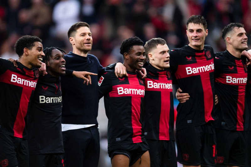 Leverkusen coach Xabi Alonso celebrates with the players after the German Bundesliga soccer match between Bayer Leverkusen and TSG 1899 Hoffenheim at BayArena. Marius Becker/dpa