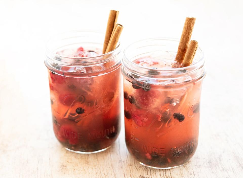 fall cinnamon and berry drink in glass jar sitting on wooden tabletop