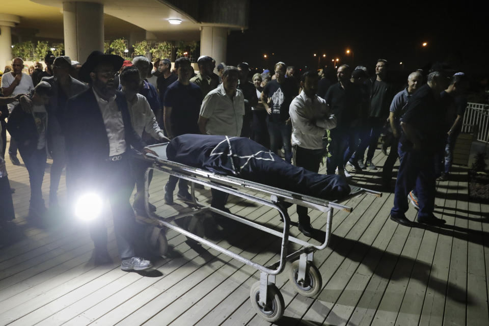 Mourners attend the funeral of Leah Yom Tov, 63, at a cemetery in Rishon Lezion, Israel, Wednesday, May 12, 2021. Yom Tov was killed from a rocket that was fired from Gaza Strip and hit her house in Rishon Lezion on May 11. (AP Photo/Sebastian Scheiner)