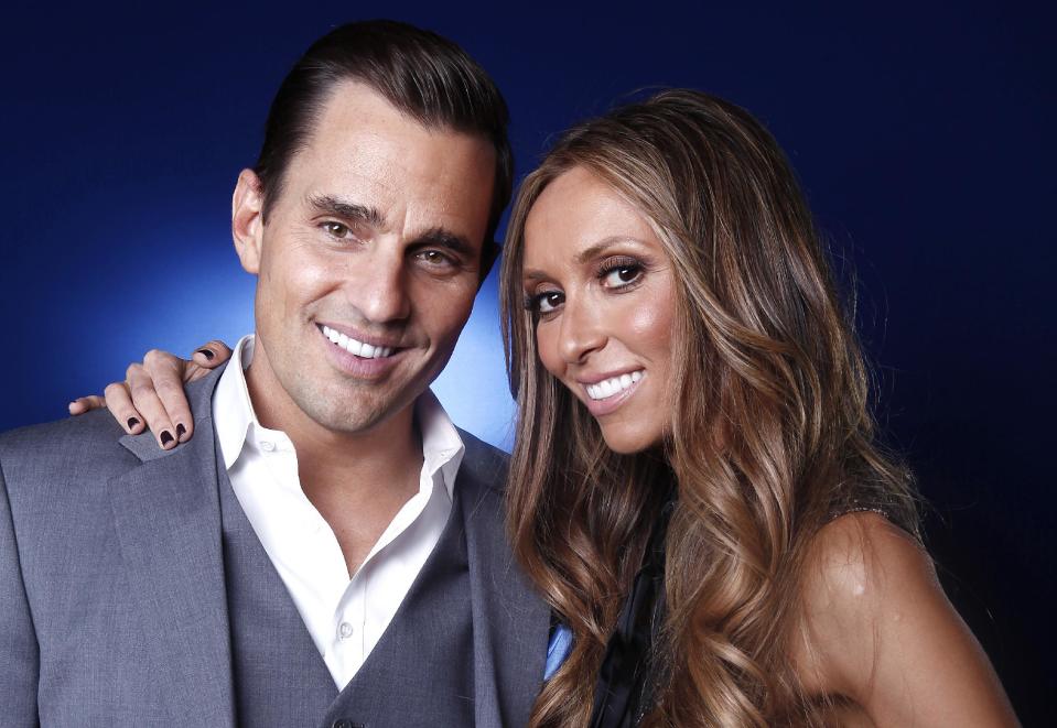 FILE - In this April 2, 2012 file photo, Bill and Giuliana Rancic pose for a portrait in New York. The Rancics are expecting their first child via a gestational surrogate. (AP Photo/Carlo Allegri, File)