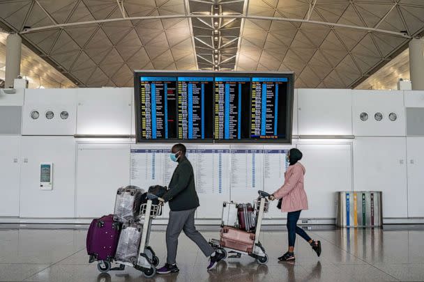 PHOTO: Travellers walk with their luggage at the departure hall of the Hong Kong International Airport, Dec. 30, 2022 in Hong Kong, China. (Anthony Kwan/Getty Images)