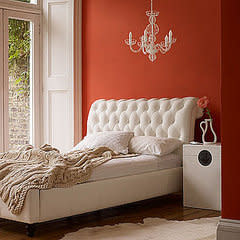 White accents and furniture keep this orange-painted bedroom modern and crisp.

Source