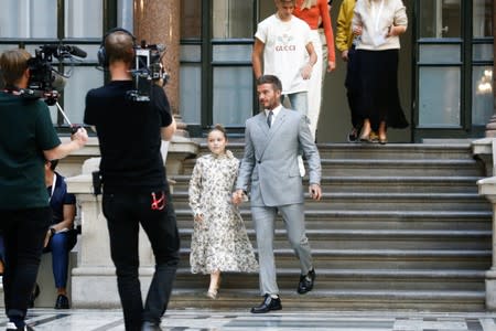 David Beckham and his children Romeo and Harper attend the Victoria Beckham catwalk show at London Fashion Week in London