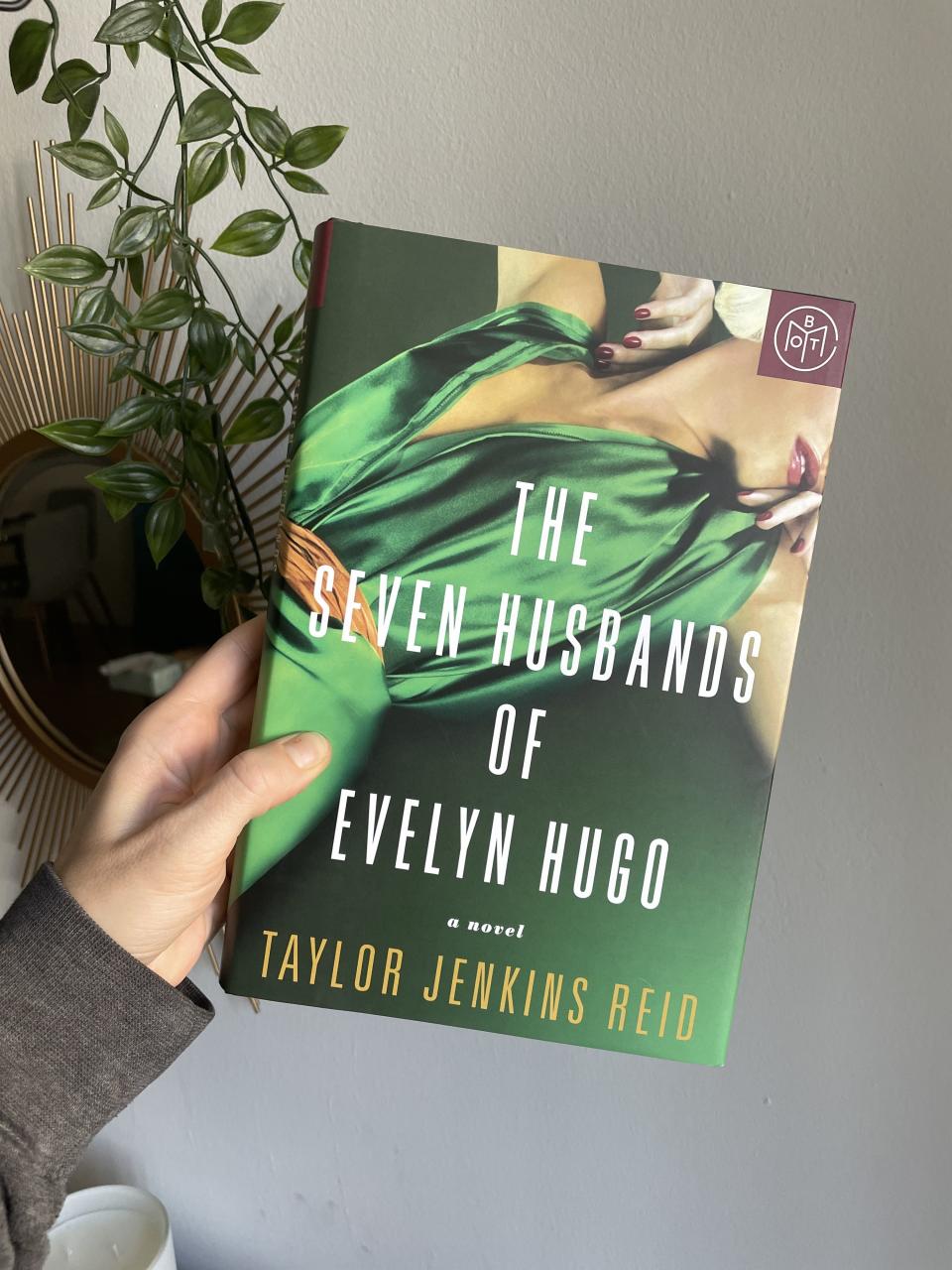 Person holds up The Seven Husbands of Evelyn Hugo by Taylor Jenkins Reid