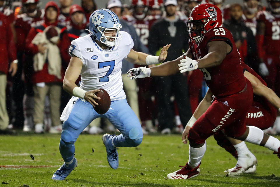 North Carolina quarterback Sam Howell (7) tries to avoid the rush of North Carolina State's Alim McNeill (29) during the first half of an NCAA college football game in Raleigh, N.C., Saturday, Nov. 30, 2019. (AP Photo/Karl B DeBlaker)