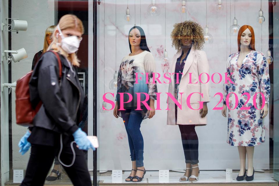 A woman wearing PPE (personal protective equipment), of a face mask as a precautionary measure against COVID-19, walks past an Evans clothing store, closed-down due to coronavirus, on Oxford Street in central London on April 27, 2020. - Prime Minister Boris Johnson on Monday made his first public appearance since being hospitalised with coronavirus three weeks ago, saying Britain was beginning to "turn the tide" on the outbreak but rejecting calls to ease a nationwide lockdown. (Photo by Tolga AKMEN / AFP) (Photo by TOLGA AKMEN/AFP via Getty Images)