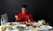 Turkish javelin thrower and Olympic hopeful Fatih Avan, 23, poses in front of his daily meal intake in Ankara May 29, 2012.