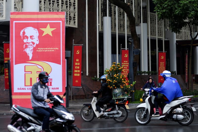 Motorbikes ride on a decorated avenue welcoming the 13th National Congress of the Communist Party of Vietnam in Hanoi