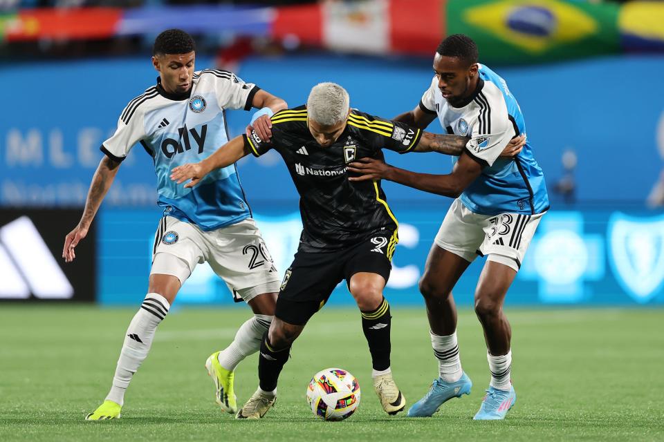 Crew forward Cucho Hernandez kicks the ball past Charlotte's Joao Pedro (20) and Iuri Tavares on Saturday.