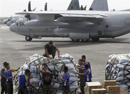 Philippine and U.S. military personnel prepare to load relief goods on a U.S. C-130 plane for victims of Typhoon Haiyan that hit the central Philippines, at Villamor Air Base in Manila November 11, 2013. REUTERS/Cheryl Ravelo