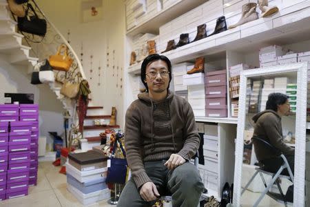 Thirty-one year-old Renato Gu poses for a portrait inside his women's shoe and accessory shop in Rome November 21, 2014. REUTERS/Tony Gentile