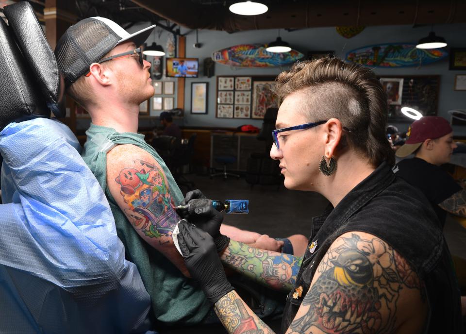 Vanessa Harper, a tattoo artist at Endless Summer Tattoos in Cocoa Beach, works on Matt Miller's arm piece of video game characters. On Sunday, Sept. 25,  the artists at Endless Summer Tattoos are doing specific  tattoos for $100-$200 and donating a portion of the proceeds to a reproductive rights group.