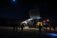 Workers process aid that will be shipped on a plane of emergency relief to Syria, in Baghdad