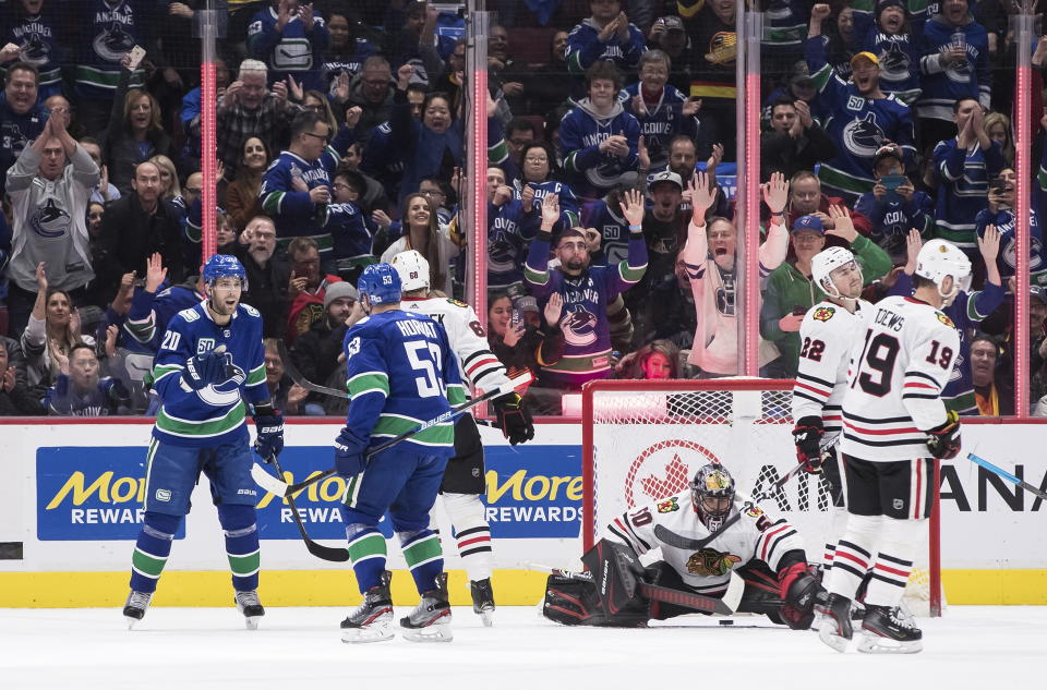 Vancouver Canucks' Brandon Sutter (20) and Bo Horvat (53) celebrate Horvat's goal against Chicago Blackhawks goalie Corey Crawford (50) as Slater Koekkoek (68), Ryan Carpenter (22) and Jonathan Toews (19) skate nearby during the first period of an NHL hockey game Wednesday, Feb. 12, 2020, in Vancouver, British Columbia. (Darryl Dyck/The Canadian Press via AP)