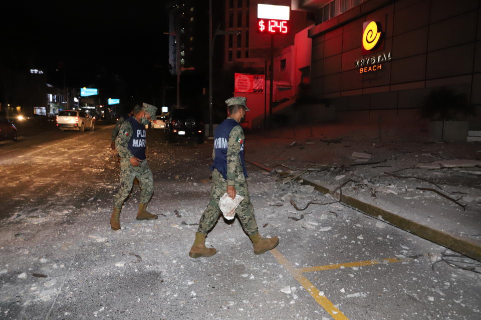 Mexican Marines walk on a street covered by debris after a strong earthquake in Acapulco, Mexico, Tuesday, Sept. 7, 2021. The quake struck southern Mexico near the resort of Acapulco, causing buildings to rock and sway in Mexico City nearly 200 miles away. (AP Photo/ Bernardino Hernandez)