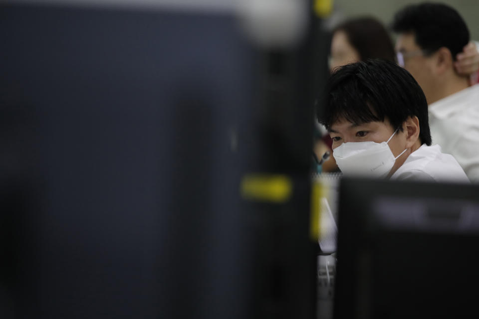 A currency trader wearing a face mask watches computer monitors at the foreign exchange dealing room in Seoul, South Korea, Wednesday, May 27, 2020. Major Asian stock markets have declined as US-Chinese tension over Hong Kong competes with optimism about recovery from the coronavirus pandemic. (AP Photo/Lee Jin-man)