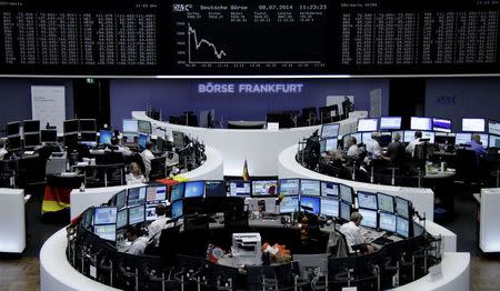 Traders are pictured at their desks in front of the DAX board at the Frankfurt stock exchange July 8, 2014. REUTERS/Remote/Stringer