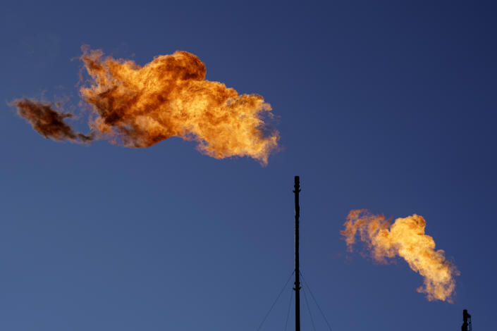 Flares burn off methane and other hydrocarbons at an oil and gas facility in Lenorah, Texas, Friday, Oct. 15, 2021. Massive amounts of methane are venting into the atmosphere from oil and gas operations across the Permian Basin, new aerial surveys show. The emission endanger U.S. targets for curbing climate change. (AP Photo/David Goldman)