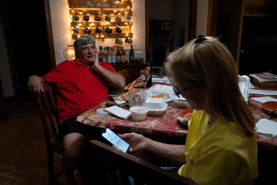 Lee Carducci laughs with his wife, Keirstie Carducci, as she replies to a text about a rescue animal past 10 p.m. while eating dinner in Ottawa Lake on Friday, July 28, 2023. The couple joked about putting the phone on silent for once, to which Lee playfully replied, "I wish I could put you on silent," causing them both to laugh. Jokes aside, Lee is a major support system for Keirstie, not only funding her animal care organization, but by helping in any way he can when he's not working himself. "He never complains no matter what I get in here or how much it costs," Keirstie said. Lee helps finish Keirstie's stall duties at the end of the day and waits for her to finish feeding before having dinner, which is past 11 p.m. on some nights.