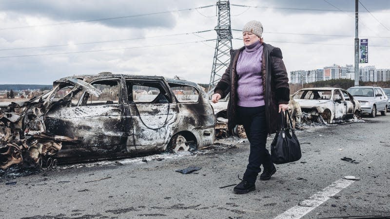 IRPIN, UKRAINE - MARCH 07: A woman walks in front of burned cars on a bridge in Irpin, on March 7, 2022, in Irpin, Ukraine. The Ukrainian army is resisting for the moment the heavy Russian siege in some of its cities, such as Irpin and Kiev, where fighting is intensifying. The United Nations estimates that the number of Ukrainian refugees could reach 1.5 million. 