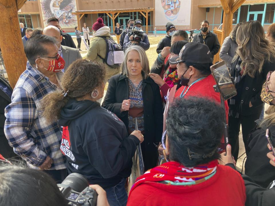 FILE - Family members of missing and slain Native Americans talk with New Mexico Gov. Michelle Lujan Grisham, center, after she signed legislation during a ceremony in Albuquerque, N.M. on Thursday, Feb. 24, 2022. New Mexico's Democratic governor says she believes vetting of her Cabinet members is crucial. But with two weeks remaining in the legislative session, she has yet to submit her nominee to oversee the state Indian Affairs Department to the Senate. (AP Photo/Susan Montoya Bryan, File)