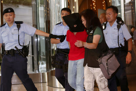 A female suspect is arrested by police officers after a woman opened fire and wounded four people at a park outside Taikoo Shing in Hong Kong, China June 26, 2018.Â REUTERS/Bobby Yip