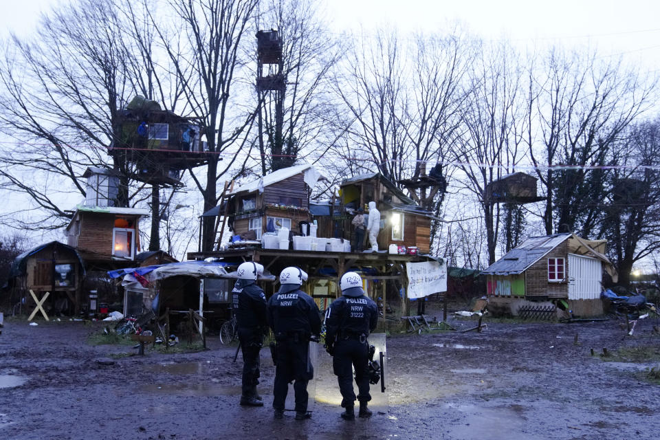 Police officers stand inside a camp of climate activists at the village Luetzerath, near Erkelenz, Germany, Thursday, Jan. 12, 2023. Police have entered the condemned village in to evict the climate activists holed up at the site in an effort to prevent its demolition, to make way for the expansion of a coal mine. (AP Photo/Michael Probst)