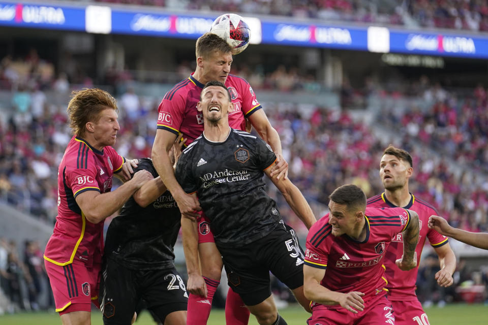 St. Louis City's Lucas Bartlett heads the ball away from Houston Dynamo's Daniel Steres (5) during the first half of an MLS soccer match Saturday, June 3, 2023, in St. Louis. (AP Photo/Jeff Roberson)