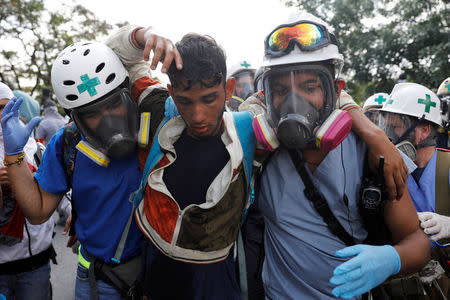 Volunteers help an injured demonstrator (C) during a rally against Venezuela's President Nicolas Maduro in Caracas, Venezuela April 24, 2017. REUTERS/Carlos Garcia Rawlins