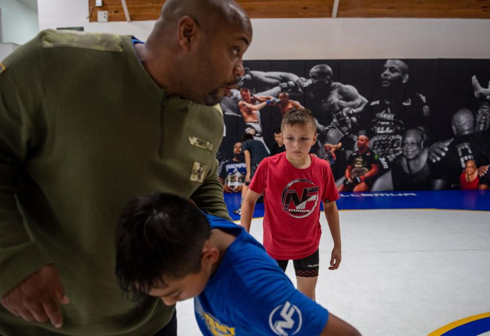 Daniel 'DC' Cormier, former UFC heavyweight champion demonstrates a wrestling move for Casey Bittner, a 10-year old wrestler from Salinas at the Daniel Cormier Wrestling Academy in Gilroy, Calif., on Tuesday  Nov. 23, 2021. 