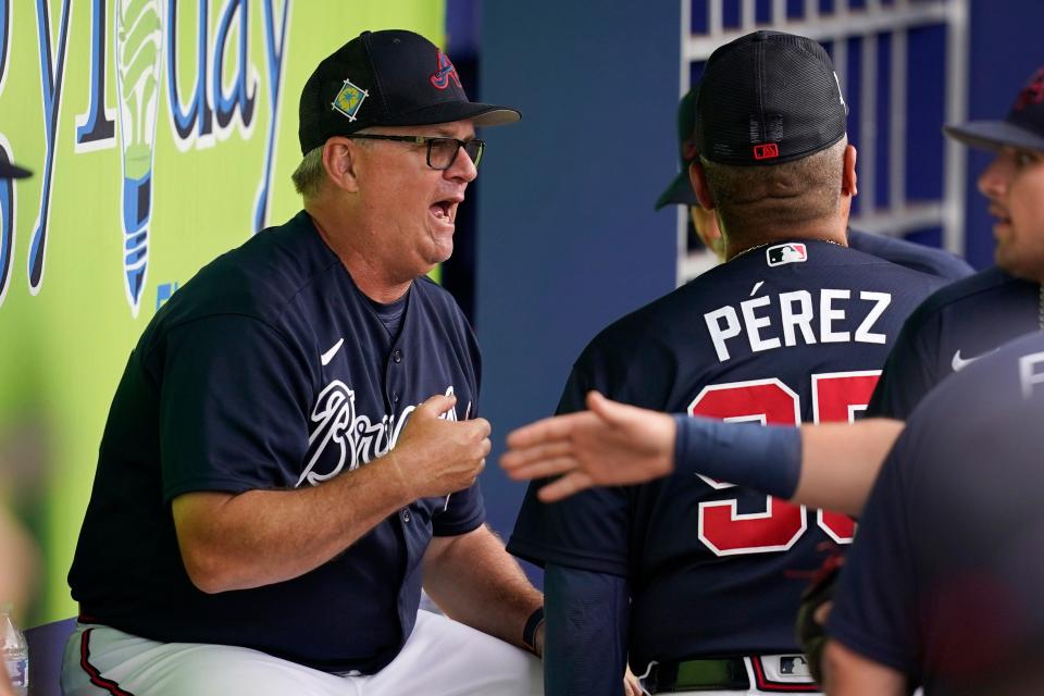 Atlanta Braves hitting coach Kevin Seitzer, left, talks with players and coaches in the dugout prior to a spring training baseball game against the Boston Red Sox at CoolToday Park, Sunday, April 3, 2022, in North Port, Fla.