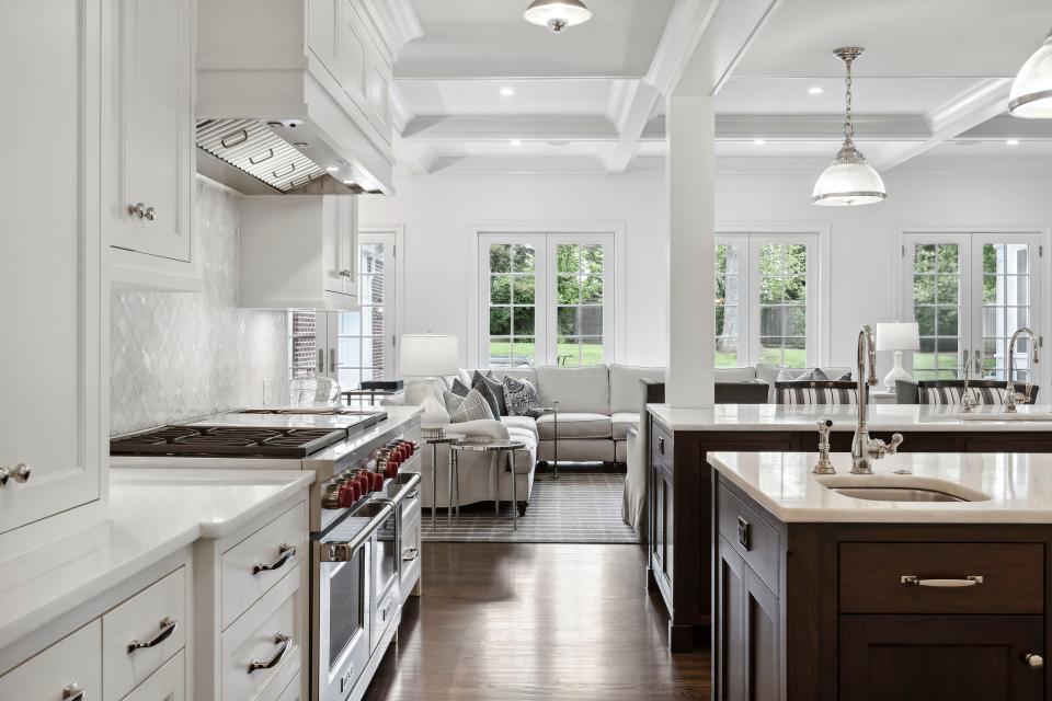 A modern, open kitchen leading to a living room.