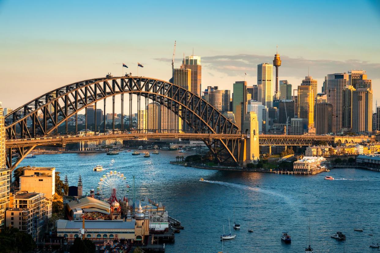 cityscape image of sydney, australia with harbor bridge and sydney skyline during sunset vacation and travel in australia