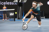 Stefanos Tsitsipas of Greece plays a backhand return to Mikael Ymer of Sweden during their first round match at the Australian Open tennis championships in Melbourne, Australia, Tuesday, Jan. 18, 2022. (AP Photo/Hamish Blair)