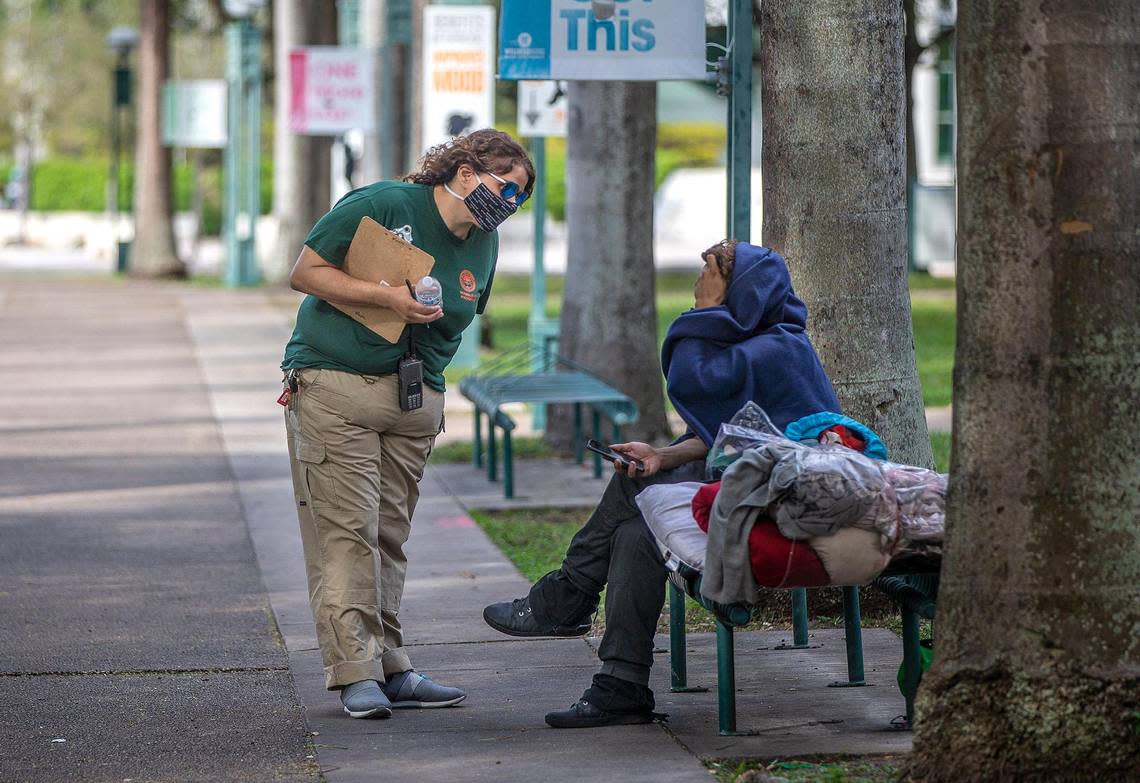 Maxie Espinosa, City of Miami outreach referral specialist, tries to persuade a homeless person in downtown Miami to be taken to shelter to stay ahead of the chilly weekend on Friday, Jan. 28, 2022.