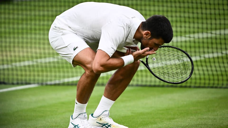 Novak Djokovic kisses the grass after beating Jannik Sinner. - Sebastien Bozon/AFP/Getty Images