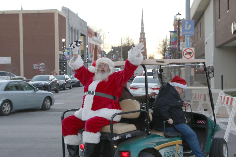 Santa Claus greets the crowd in Downtown Fremont after arriving by golf cart as he gets ready to visit with children and hear their holiday dreams at Santa's House. Friday's activities marked the official start of Downtown Fremont's holiday season.