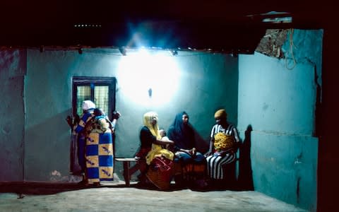 Women visit Rahmatu under the cover of darkness to avoid becoming the subject of local gossip in this deeply conservative part of northern Ghana - Credit: Simon Townsley/The Telegraph