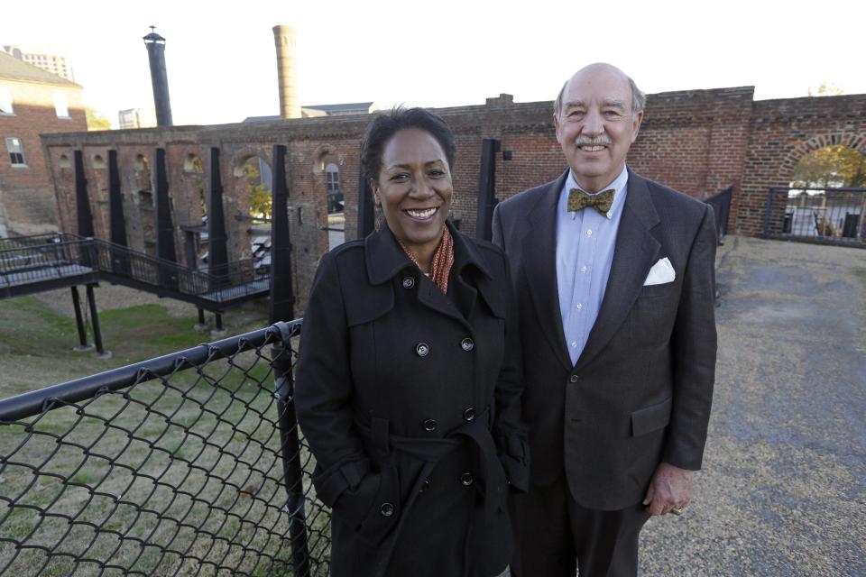 Christy Coleman, left, director of the American Civil War Center at Tredegar Iron Works, left, and Waite Rawls of the Museum of the Confederacy, pose in front of the ruins of the old Tredegar Iron Works in Richmond, Va., Wednesday, Nov. 13, 2013. (AP Photo/Steve Helber)