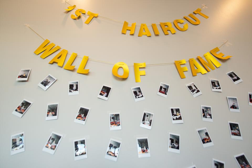 Children receiving their first haircut are honored with a photo on a wall of fame at Clipeez.