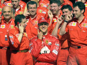 Schumacher, centre and team manager Jean Todt, front left pose with members of the Ferrari team at the Spanish Grand Prix at the Montmelo track just outside Barcelona, Spain, in 2002. (Getty)