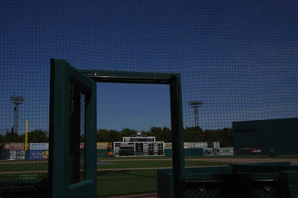 A manual scoreboard is seen through an opening door to the field at Rickwood Field, Monday, June 10, 2024, in Birmingham, Ala. Rickwood Field, known as one of the oldest professional ballpark in the United States and former home of the Birmingham Black Barons of the Negro Leagues, will be the site of a special regular season game between the St. Louis Cardinals and San Francisco Giants on June 20, 2024. (AP Photo/Brynn Anderson)