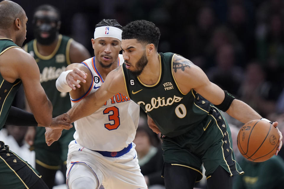 New York Knicks guard Josh Hart (3) defends as Boston Celtics forward Jayson Tatum (0) drives toward the basket in the second half of an NBA basketball game, Sunday, March 5, 2023, in Boston. (AP Photo/Steven Senne)