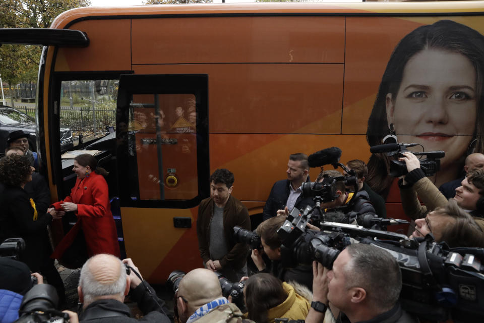 Britain's Liberal Democrats leader Jo Swinson, second left, gets off her campaign bus and is greeted by Humaira Ali, left, the Liberal Democrats candidate for Southwark and Old Bermondsey as she arrives to campaign at Cafe Amisha in the Southwark and Old Bermondsey constituency in south London, Saturday, Nov. 16, 2019. (AP Photo/Matt Dunham)