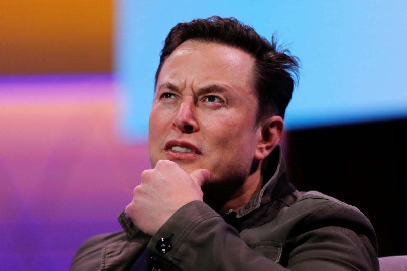 Elon Musk, hand on chin, looking up and confused.